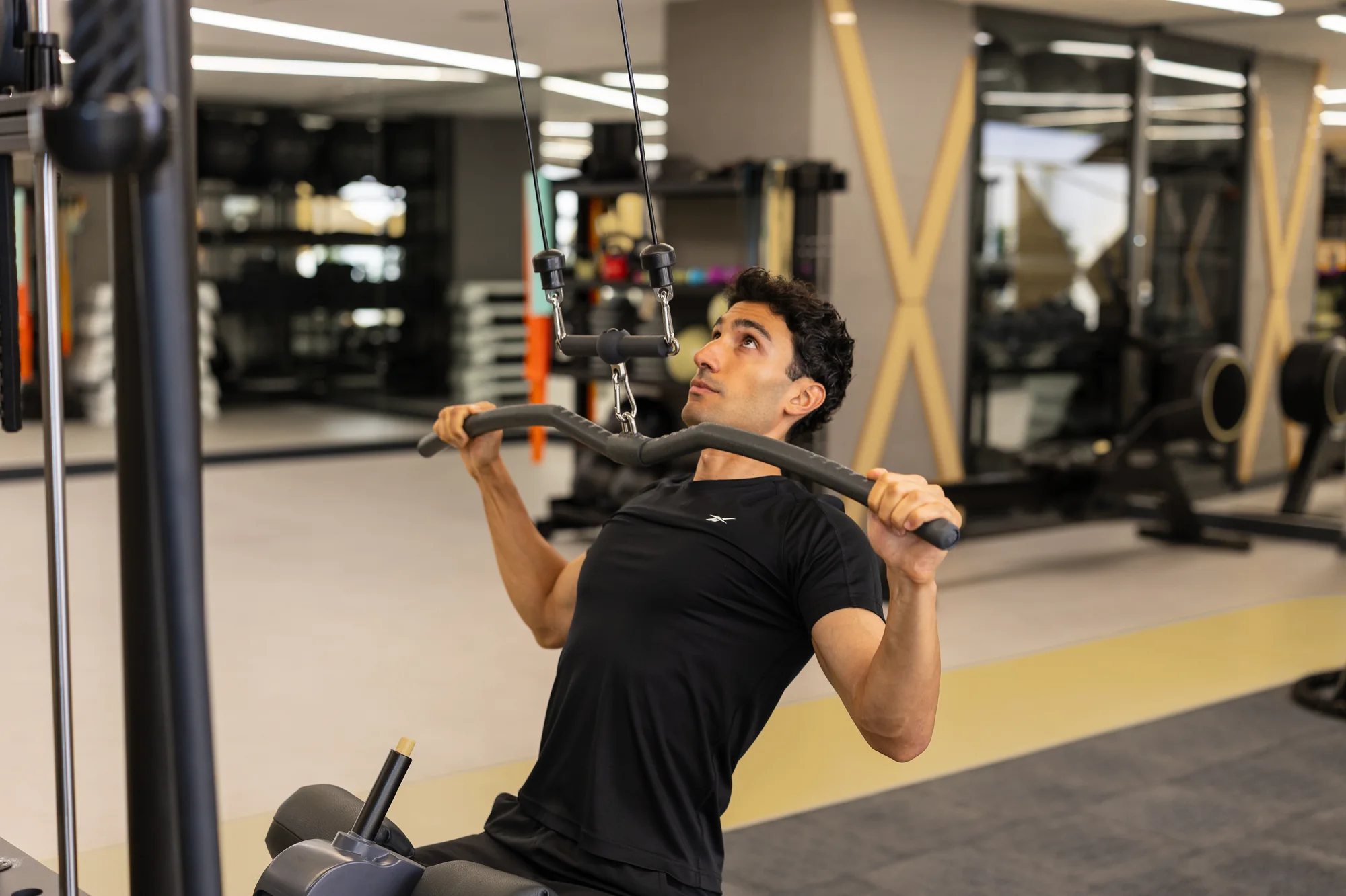 Hamdi Kambay, lat pulldown makinesinde antrenman yaparken